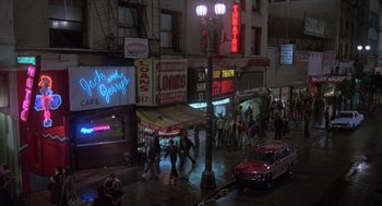 Movie still from “Stripes” (1981), directed by Ivan Reitman – A group of people walking down a street at night; Extreme Wide shot, High angle