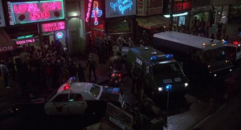 Movie still from “Stripes” (1981), directed by Ivan Reitman – A group of police cars parked on the side of the street; Extreme Wide shot, High angle
