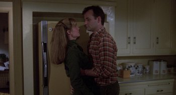 Movie still from “Stripes” (1981), directed by Ivan Reitman – A man and a woman standing next to each other in a kitchen; Medium shot, Low angle