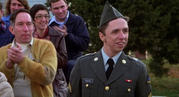 Movie still from “Stripes” (1981), directed by Ivan Reitman – A man in a military uniform with a hat on his head; Medium shot, Over the shoulder angle