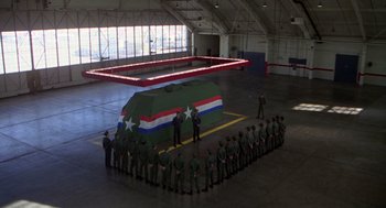 Movie still from “Stripes” (1981), directed by Ivan Reitman – A group of men standing around a military vehicle; Extreme Wide shot, High angle