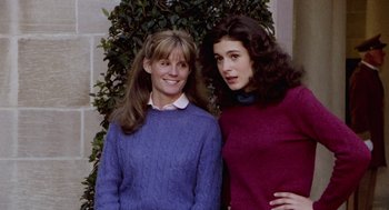 Movie still from “Stripes” (1981), directed by Ivan Reitman – Two young women standing next to each other in front of a tree; Medium shot, Low angle