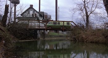 Movie still from “Stripes” (1981), directed by Ivan Reitman – A train is crossing a bridge over a river; Wide shot, Low angle