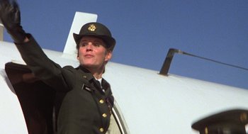 Movie still from “Stripes” (1981), directed by Ivan Reitman – A woman in a military uniform standing in front of an airplane; Medium shot, Low angle