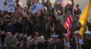 Movie still from “Stripes” (1981), directed by Ivan Reitman – A group of people in military uniforms are clapping; Wide shot, High angle