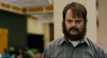 Movie still from “Super” (2010), directed by James Gunn – A man with a beard and a mustache; Close Up shot, Over the shoulder angle