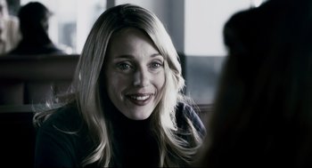 Movie still from “Super” (2010), directed by James Gunn – A woman with long blonde hair smiles at the camera; Close Up shot, Over the shoulder angle