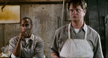 Movie still from “Super” (2010), directed by James Gunn – A man in an apron standing next to another man in an apron; Medium shot, High angle
