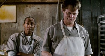 Movie still from “Super” (2010), directed by James Gunn – Two men wearing aprons standing next to each other; Medium shot, Low angle