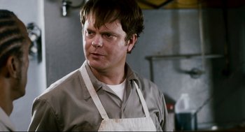 Movie still from “Super” (2010), directed by James Gunn – A man wearing an apron and looking to his left; Close Up shot, Over the shoulder angle