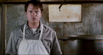 Movie still from “Super” (2010), directed by James Gunn – A man wearing an apron standing in front of an oven; Close Up shot, Low angle