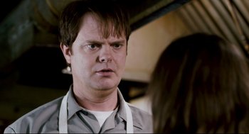 Movie still from “Super” (2010), directed by James Gunn – A man in a gray shirt is looking at a woman; Close Up shot, Over the shoulder angle