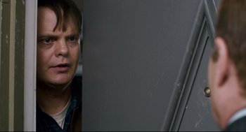 Movie still from “Super” (2010), directed by James Gunn – A man standing next to a wall with his mouth open; Close Up shot, Over the shoulder angle