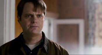 Movie still from “Super” (2010), directed by James Gunn – A person wearing a brown jacket; Close Up shot, Over the shoulder angle