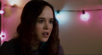 Movie still from “Super” (2010), directed by James Gunn – A woman with long brown hair stares into the camera; Close Up shot, Over the shoulder angle