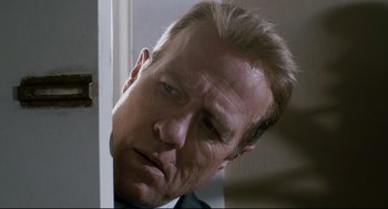 Movie still from “Super” (2010), directed by James Gunn – A person leaning against a wall; Close Up shot, Low angle