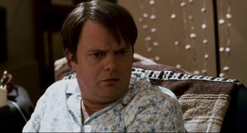 Movie still from “Super” (2010), directed by James Gunn – A person sitting on a couch; Close Up shot, Over the shoulder angle