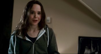 Movie still from “Super” (2010), directed by James Gunn – A young woman in a gray hoodie is smiling; Close Up shot, Over the shoulder angle