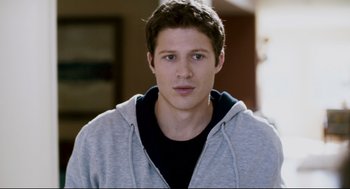 Movie still from “Super” (2010), directed by James Gunn – A man in a black shirt and a gray hoodie; Close Up shot, Over the shoulder angle