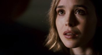 Movie still from “Super” (2010), directed by James Gunn – A young woman's face in the dark; Close Up shot, Over the shoulder angle