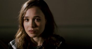 Movie still from “Super” (2010), directed by James Gunn – A person with long brown hair; Close Up shot, Over the shoulder angle