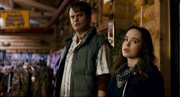 Movie still from “Super” (2010), directed by James Gunn – A man and a woman standing next to each other; Medium shot, Over the shoulder angle