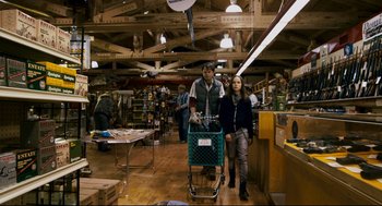 Movie still from “Super” (2010), directed by James Gunn – A man and a woman pushing a shopping cart in a store; Wide shot, Over the shoulder angle