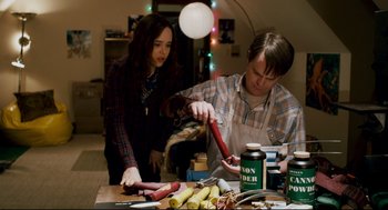 Movie still from “Super” (2010), directed by James Gunn – A man and a woman preparing food on a table; Medium shot, High angle