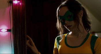 Movie still from “Super” (2010), directed by James Gunn – A woman wearing a green and yellow mask; Close Up shot, Low angle