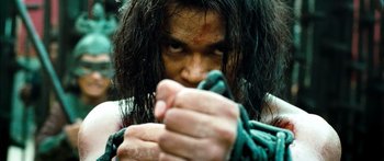 Movie still from “Ong Bak 3” (2010), directed by Tony Jaa – A person holding a rope; Extreme Close Up shot, Low angle