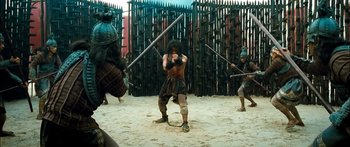 Movie still from “Ong Bak 3” (2010), directed by Tony Jaa – A group of men in costume holding swords in the sand; Wide shot, Low angle