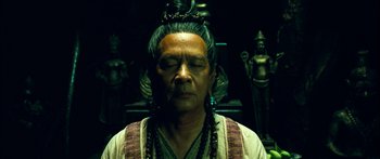 Movie still from “Ong Bak 3” (2010), directed by Tony Jaa – An older man wearing a long necklace and wearing a crown; Close Up shot, High angle