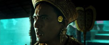 Movie still from “Ong Bak 3” (2010), directed by Tony Jaa – A person wearing a hat and earrings; Close Up shot, Low angle