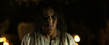 Movie still from “Ong Bak 3” (2010), directed by Tony Jaa – A person with long black hair; Close Up shot, Low angle