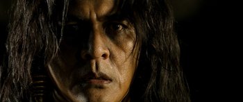 Movie still from “Ong Bak 3” (2010), directed by Tony Jaa – A man with long hair; Close Up shot, Low angle