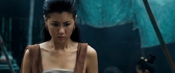 Movie still from “Ong Bak 3” (2010), directed by Tony Jaa – A person wearing a dress; Close Up shot, Over the shoulder angle