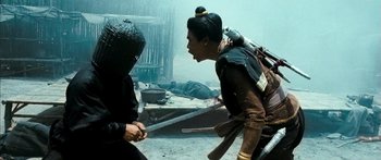 Movie still from “Ong Bak 3” (2010), directed by Tony Jaa – Two people are fighting in the middle of the street; Medium shot, Over the shoulder angle