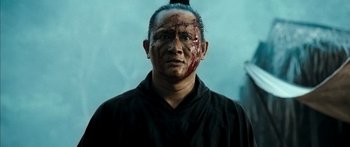 Movie still from “Ong Bak 3” (2010), directed by Tony Jaa – A man with blood all over his face and head; Close Up shot, Low angle