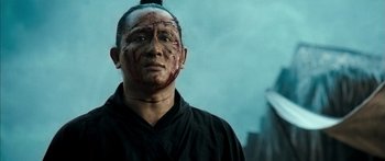 Movie still from “Ong Bak 3” (2010), directed by Tony Jaa – A man with blood all over his face and head; Close Up shot, Low angle