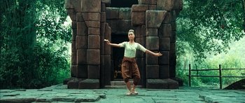 Movie still from “Ong Bak 3” (2010), directed by Tony Jaa – A person standing in front of a stone building; Wide shot, Low angle