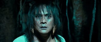 Movie still from “Ong Bak 3” (2010), directed by Tony Jaa – A woman with long green hair wearing big gold earrings; Close Up shot, Low angle