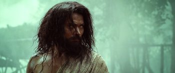 Movie still from “Ong Bak 3” (2010), directed by Tony Jaa – A man with long black hair and a beard; Close Up shot, Low angle