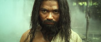Movie still from “Ong Bak 3” (2010), directed by Tony Jaa – A person with long hair and a beard; Close Up shot, Low angle