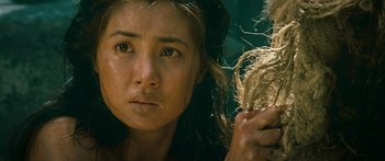 Movie still from “Ong Bak 3” (2010), directed by Tony Jaa – A person holding a hair brush; Close Up shot, Over the shoulder angle