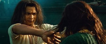 Movie still from “Ong Bak 3” (2010), directed by Tony Jaa – A woman combing her long black hair in front of a mirror; Close Up shot, Over the shoulder angle