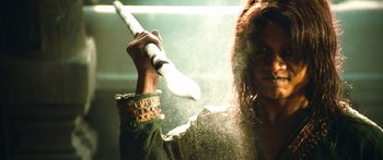 Movie still from “Ong Bak 3” (2010), directed by Tony Jaa – A woman holding a baseball bat in front of her face; Close Up shot, Low angle