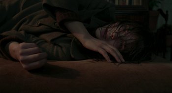 Movie still from “Suspiria” (2018), directed by Luca Guadagnino – A woman laying on the ground in a dark room; Close Up shot, High angle