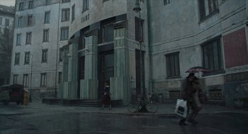 Movie still from “Suspiria” (2018), directed by Luca Guadagnino – A bicycle parked in front of a building on a rainy day; Extreme Wide shot, Low angle