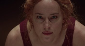 Movie still from “Suspiria” (2018), directed by Luca Guadagnino – A person with red hair and green eyes; Close Up shot, Overhead angle