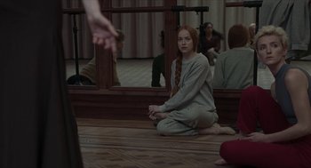 Movie still from “Suspiria” (2018), directed by Luca Guadagnino – A woman sitting on the ground in front of a mirror; Medium shot, Over the shoulder angle
